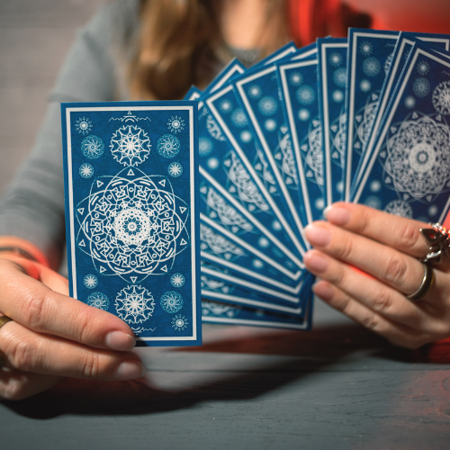 A person holding up a handful of tarot cards.